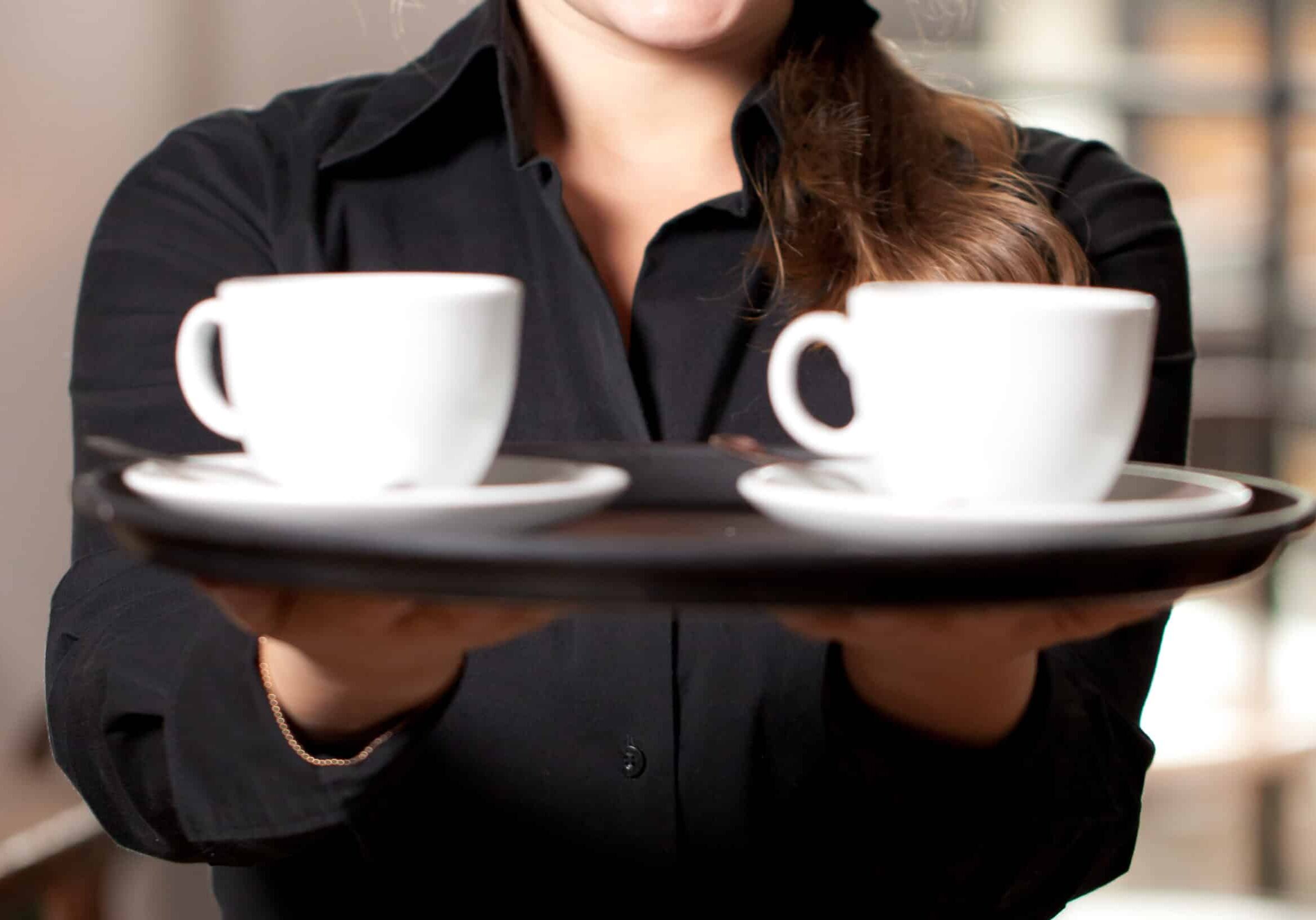 Junge kellnerin arbeitet im Cafe